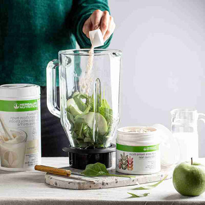 Person preparing a green smoothie with Herbal Nutrients products on a table.